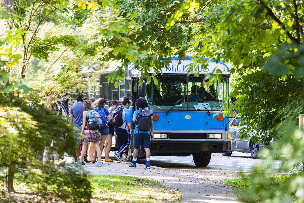 students approaching the blue bus to head to bryn mawr college