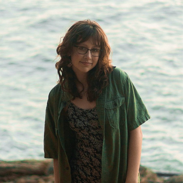 Ramona smiling for the camera with the ocean in the background