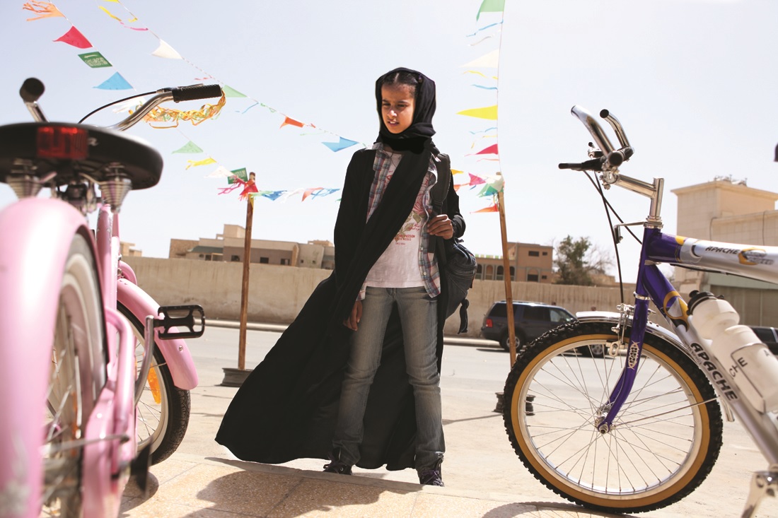 A young Saudi girl stares longingly at bicycles