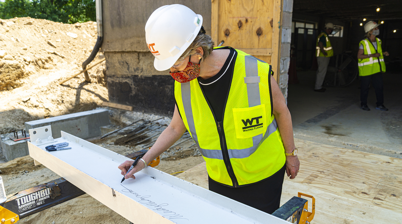 President Wendy Raymond signs the beam which will be used in the construction of the Michael Jaharis Concert Hall.