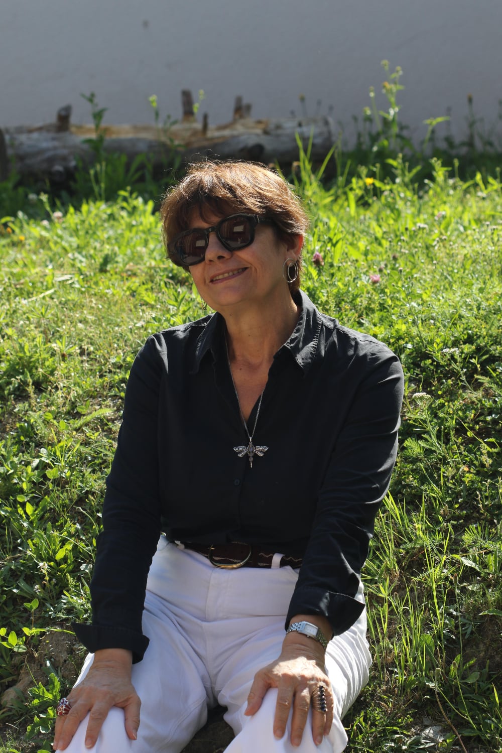 Woman with sunglasses sitting on grass