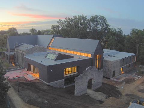 Exterior of the library under construction at sunrise.