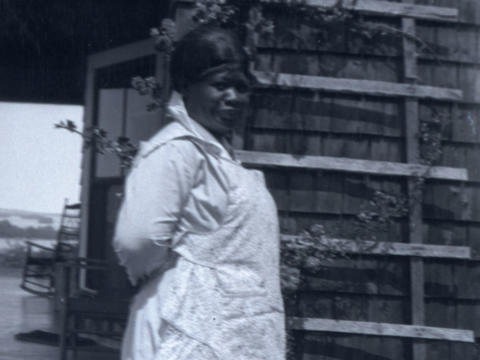 a Black woman in front of a house