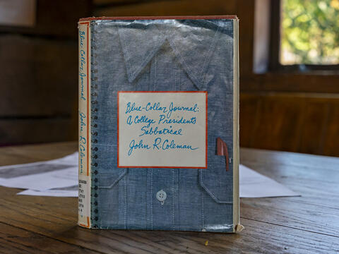 A copy of Jack Coleman's book, Blue Collar Journal, sits upright on a wooden table in Haverford's Skate House.