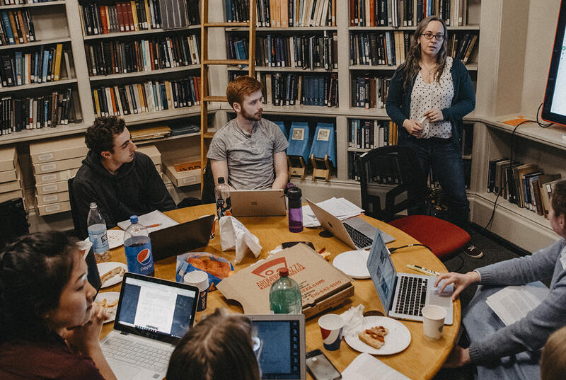 Students sit around a crowded table surrounded by bookshelves in Haverford's Strawbridge Observatory.