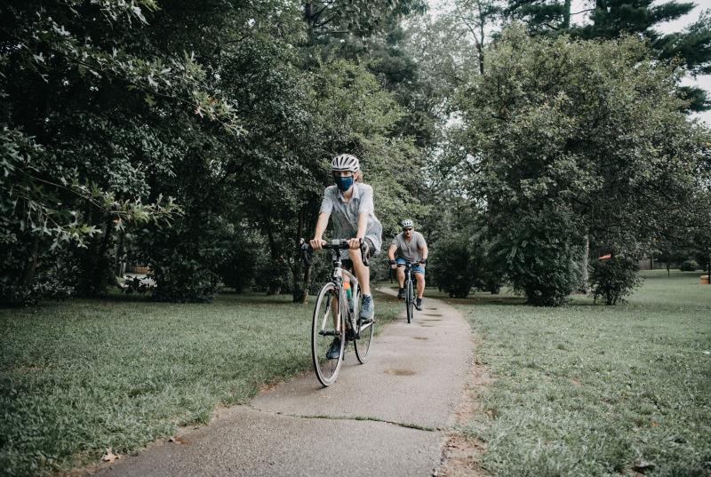 Matthew Katz '22 wearing a helmet and mask bikes part of the Main Line Greenway