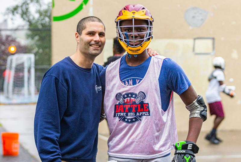 Joel Censor teaches lacrosse to students on handball courts