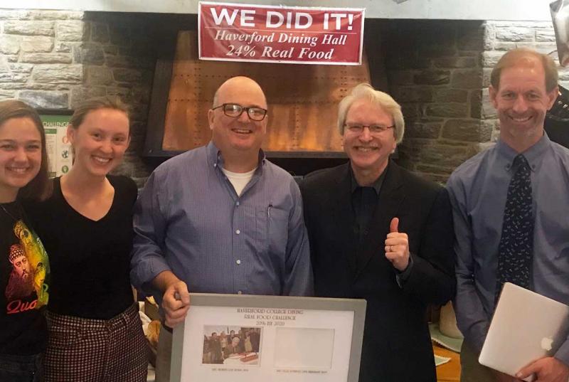 Students, Tom Mitchell, President Benston, and Jesse Lytle with a plaque acknowledging Haverford making its Real Food Challenge in the Dining Center