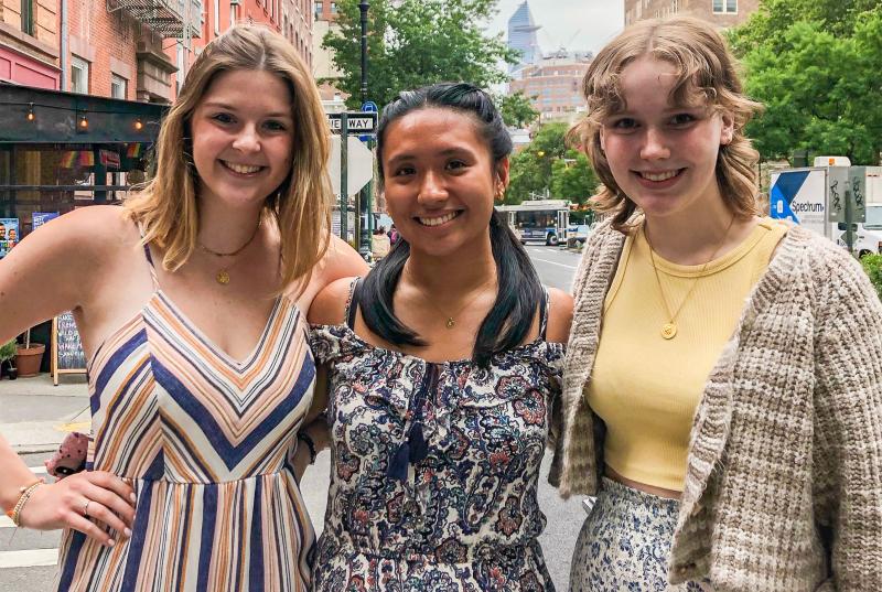 Eleanor, Kayla, and Madeline are dressed in nice clothes standing on a New York street.