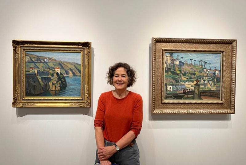 Caroyln Megumi Moss standing in front of two ornately framed paintings