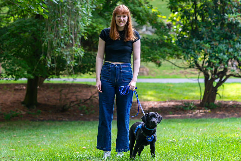 Aileen King is pictured in a portrait with a small black lab puppy. 