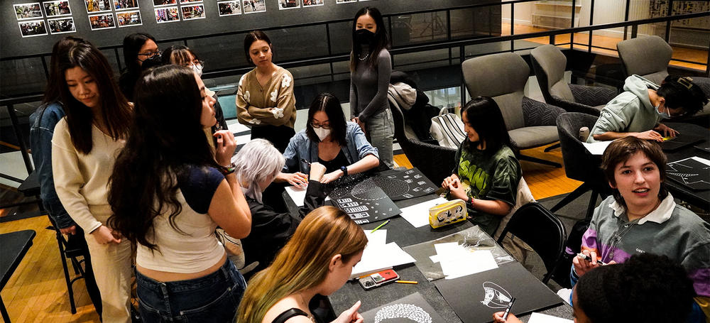 Students at a workshop working on pieces of art