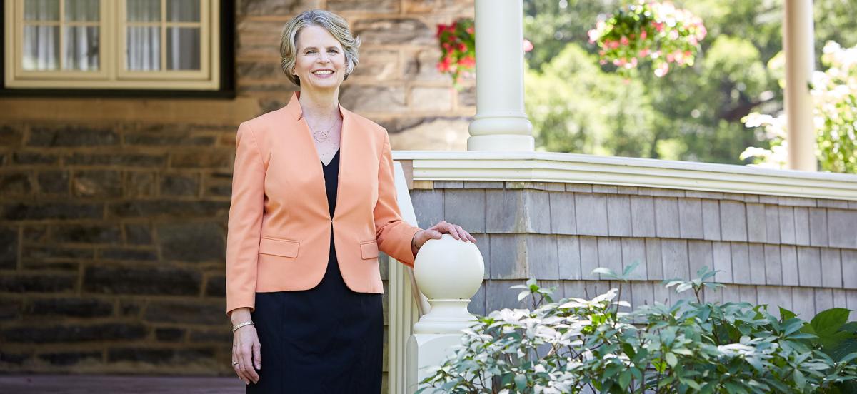Woman in business suit stand outside of house