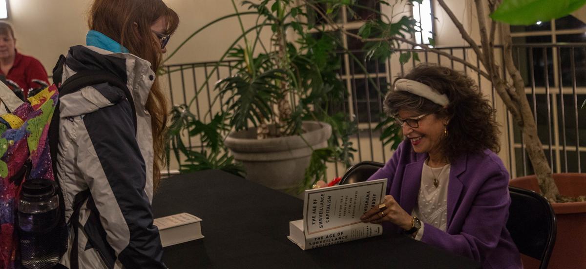 Shoshana Zuboff signs a student's copy of her book, "Surveillance Capitalism" at an event at Haverford College