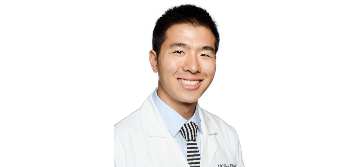 A headshot of Lawrence Wang wearing a tie and his white doctor's coat